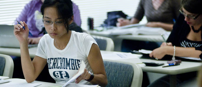 A School of Business student reviews her notes in class.