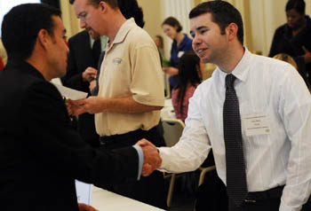 A male Point Park student meets with a potential employer at job fair on campus.