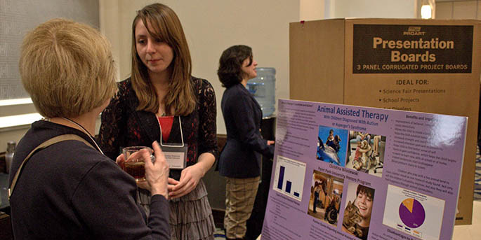 Honors student and psychology major Christina Wisniewski explains her poster on Animal Assisted Therapy and its use in treatment of children with autism or Asperger's syndrome while presenting at the Northeast Regional Honors Council Conference in Philadelphia in April 2013.