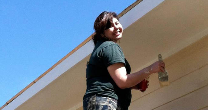 Point Park student Stephi Squeak paints siding and under the eaves on a Habitat for Humanity home near Bay St. Charles, Miss. | Photo courtesy of Katherine Sikma