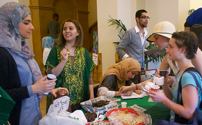 Students sample traditional food and get their name written in Arabic at the Saudi Arabian table during the Global Festivals Celebration.