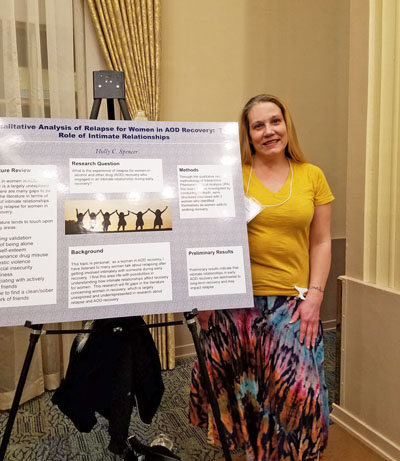 Pictured is Holly Spencer, creative writing/English and behavioral science double major with her research poster at the Undergraduate Qualitative Research Conference. | Photo by Robert McInerney, Ph.D.