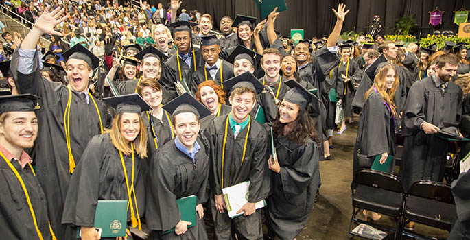 A group of new Point Park graduates wearing black caps and gowns celebrate together following the 2015 commencement ceremony at the Consol Energy Center May 2, 2015. | Photo by John Altdorfer