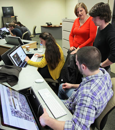 Associate Professor Heather Starr Fiedler talks with students working on the Pittsburgh Power project. Photo by Andrew Weier