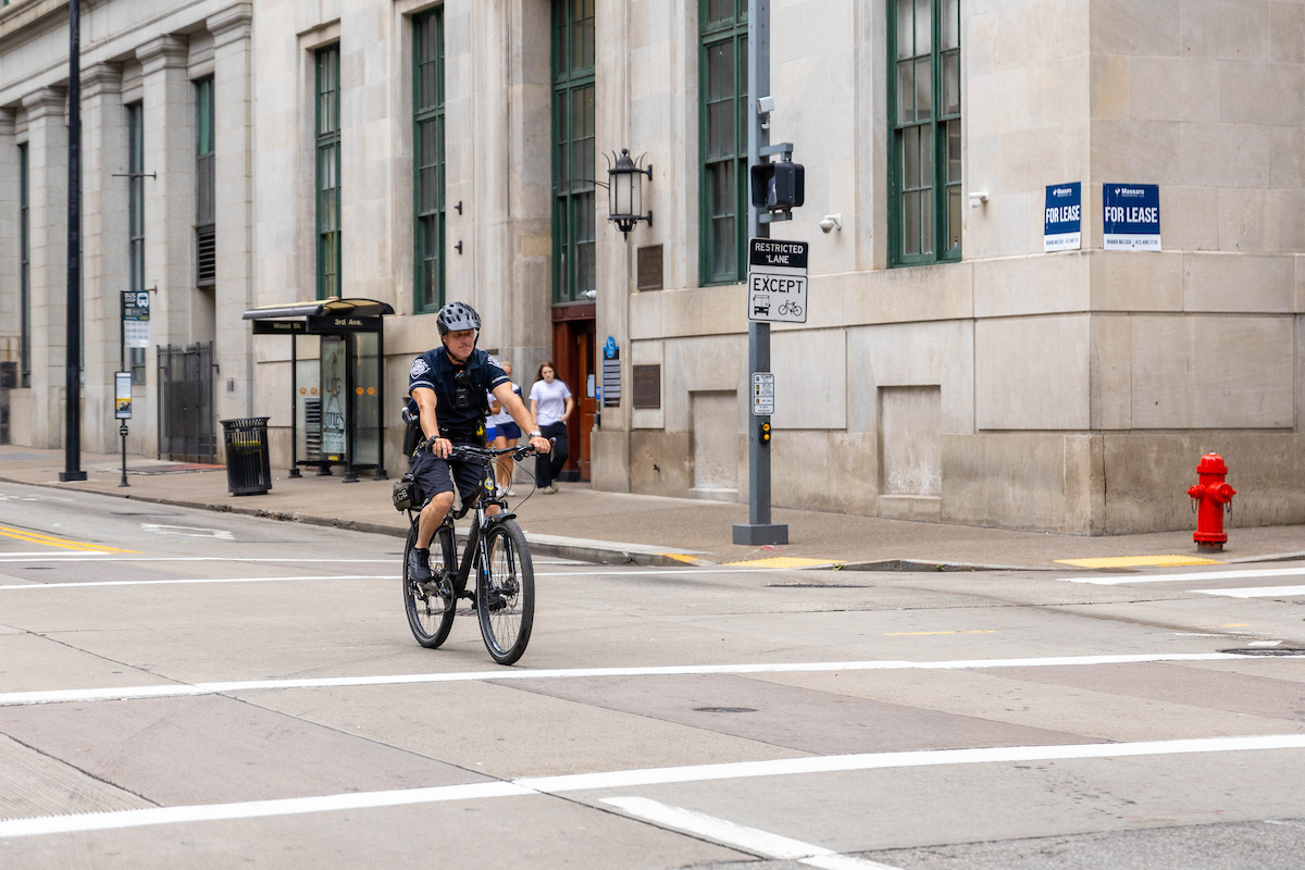 A police officer rides a bike on Wood Street.
