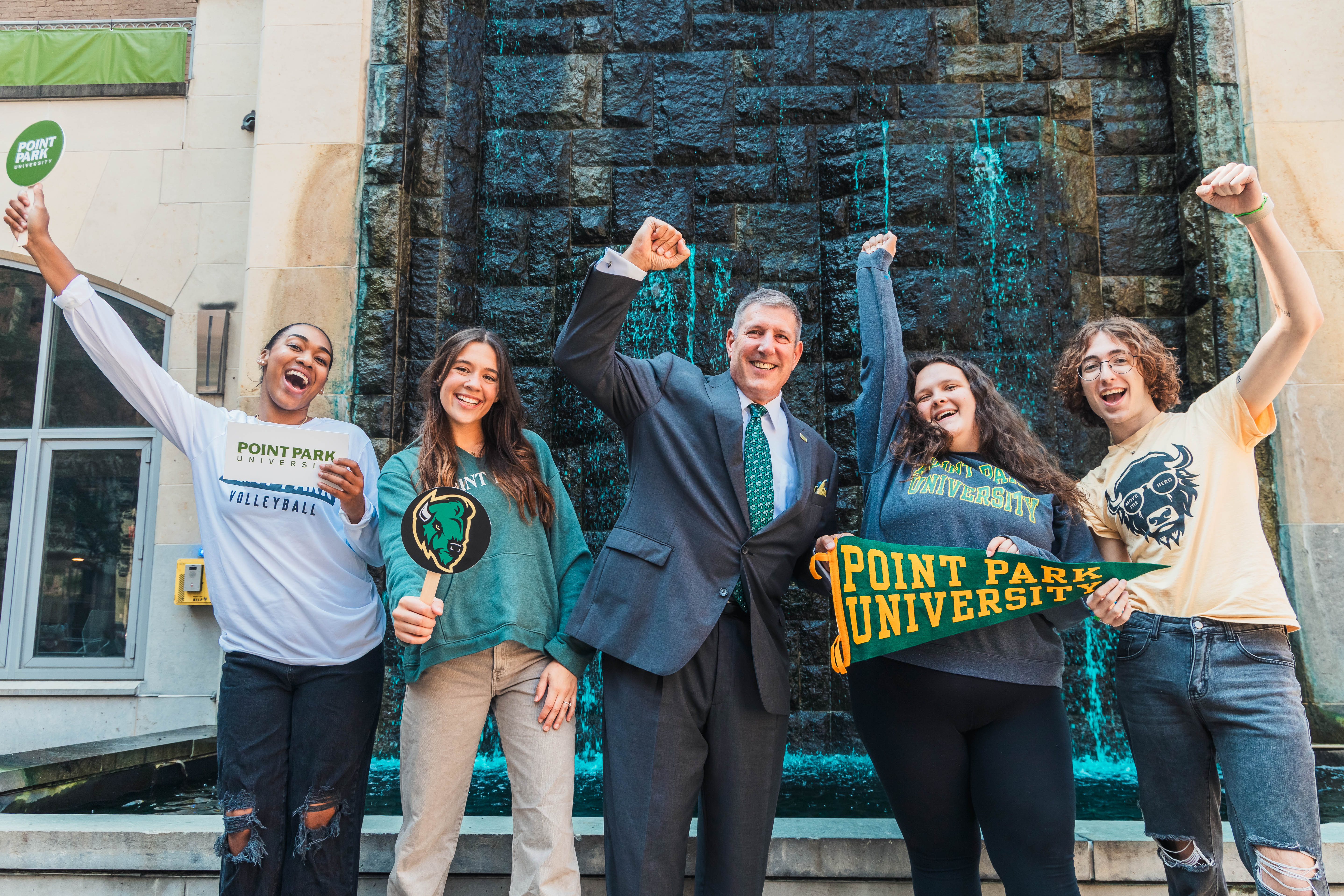 A photo of four undergraduate students beside President Brussalis in Village Park by Ethan Stoner.