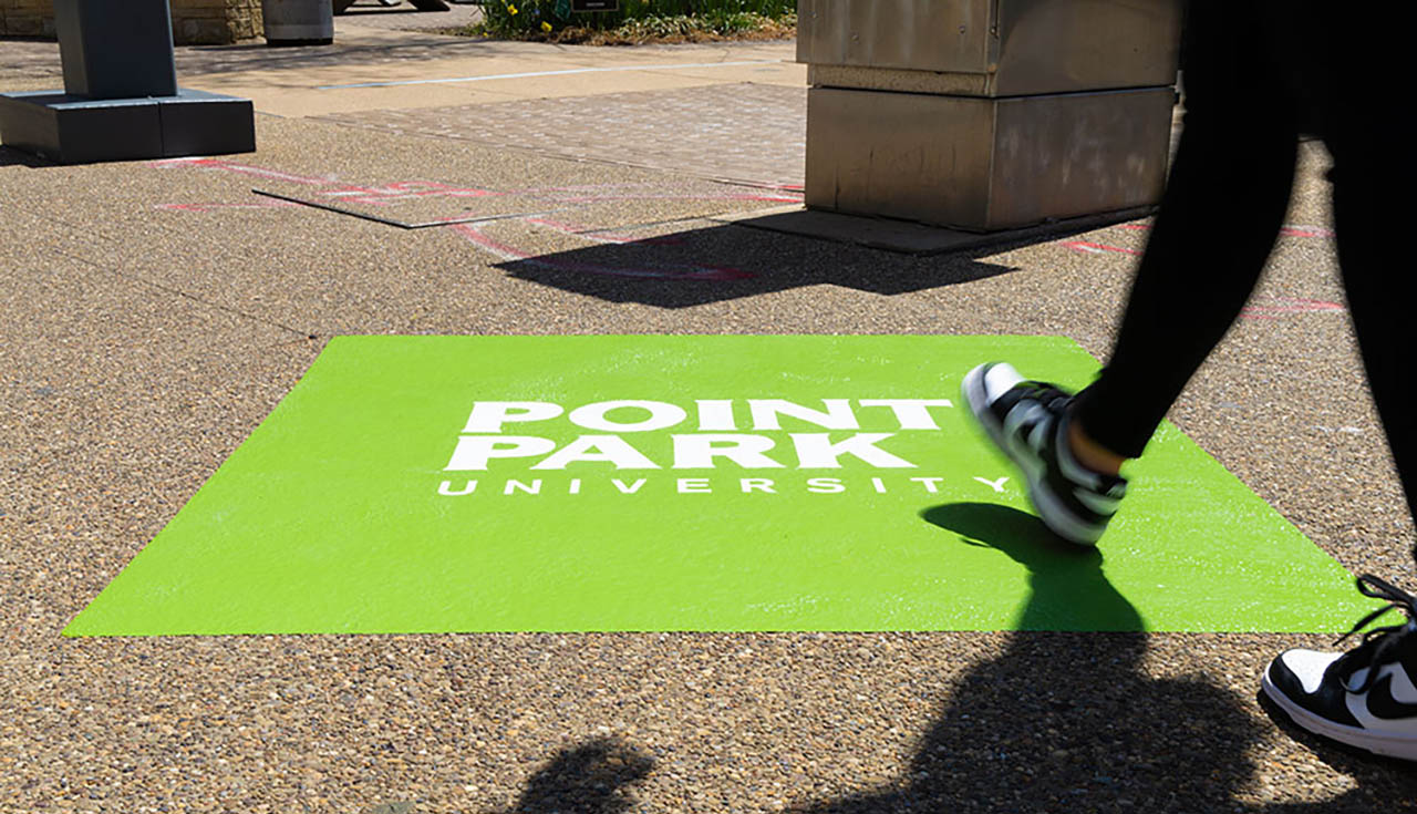 A photo of a Point Park graphic on the sidewalk on campus. 