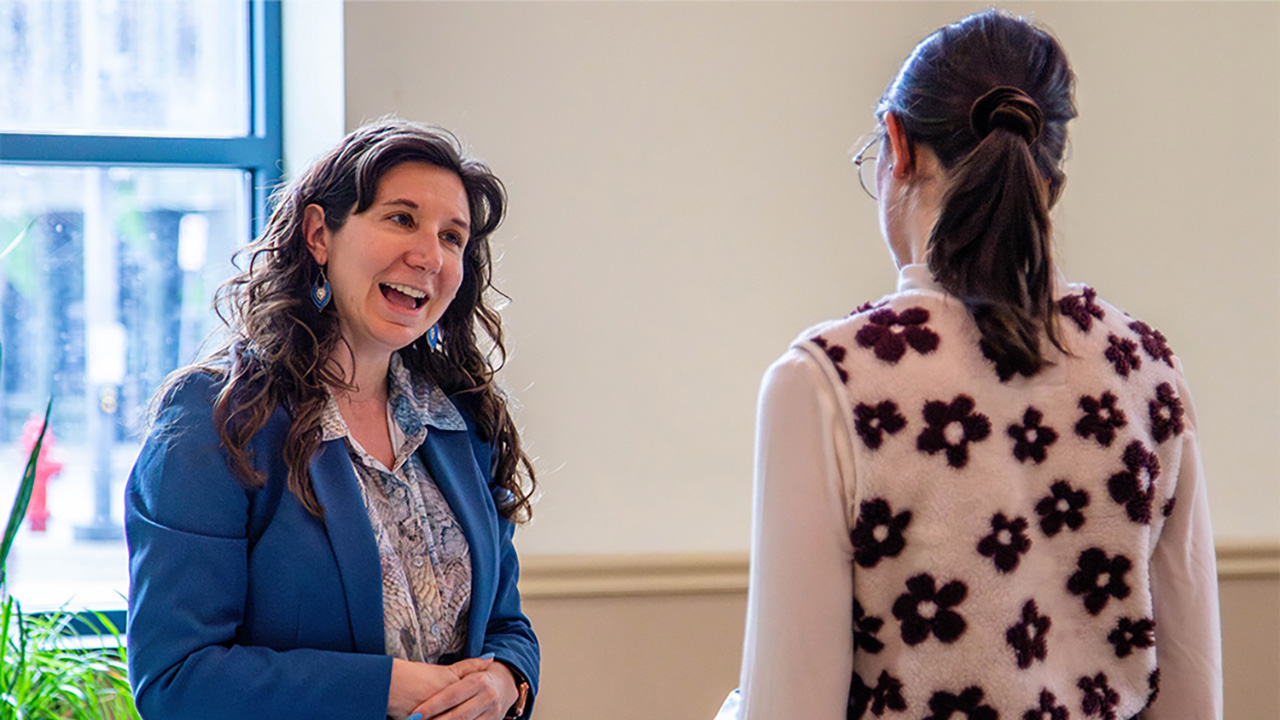Britney Brinkman, Ph.D., speaks to a student at a recent Graduate Program Fair in Point Park University's Lawrence Hall.