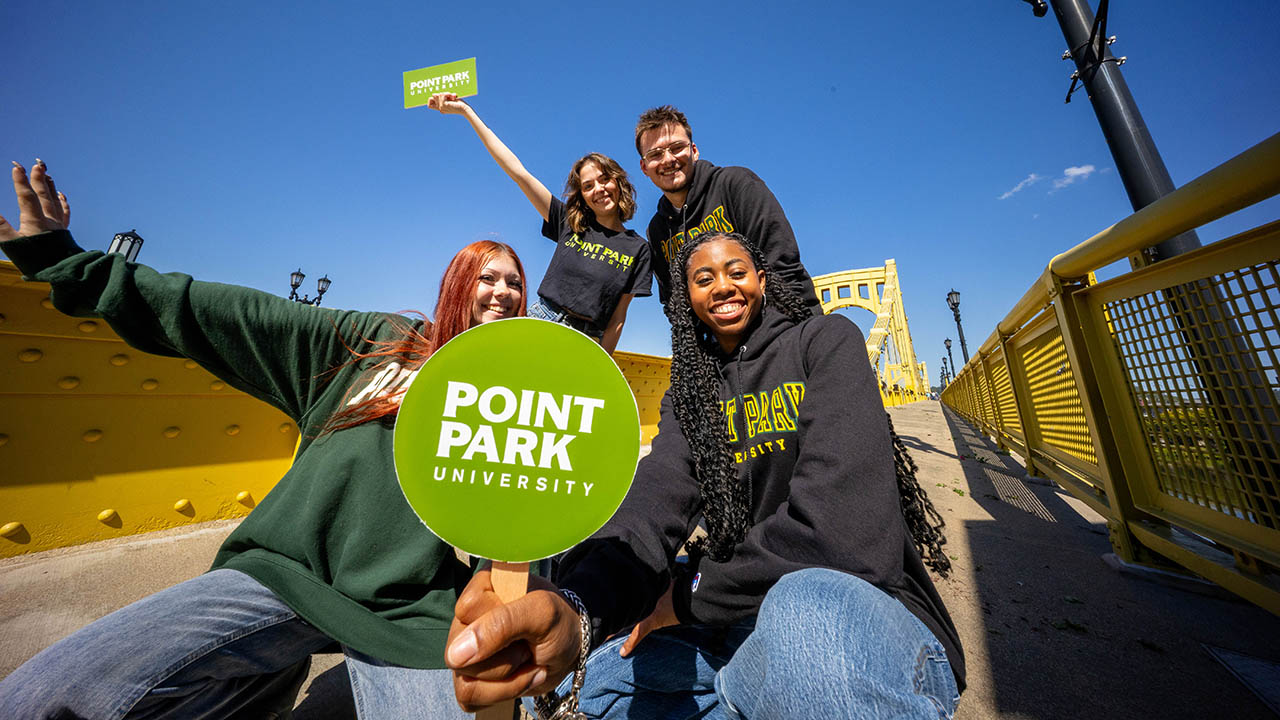 Students in Point Park clothing on a bridge in Downtown Pittsburgh.