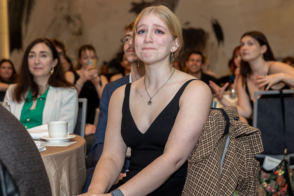A girl looks at the stage with tears in her eyes