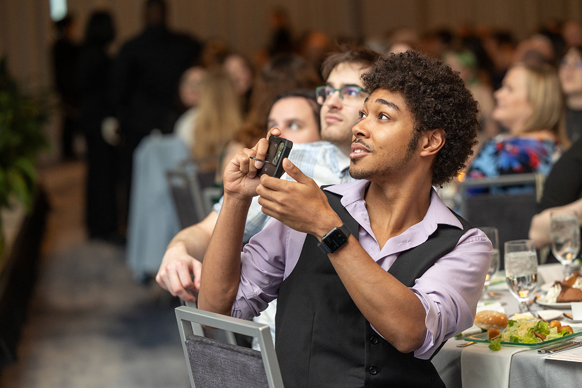 A student takes a photograph with their phone.