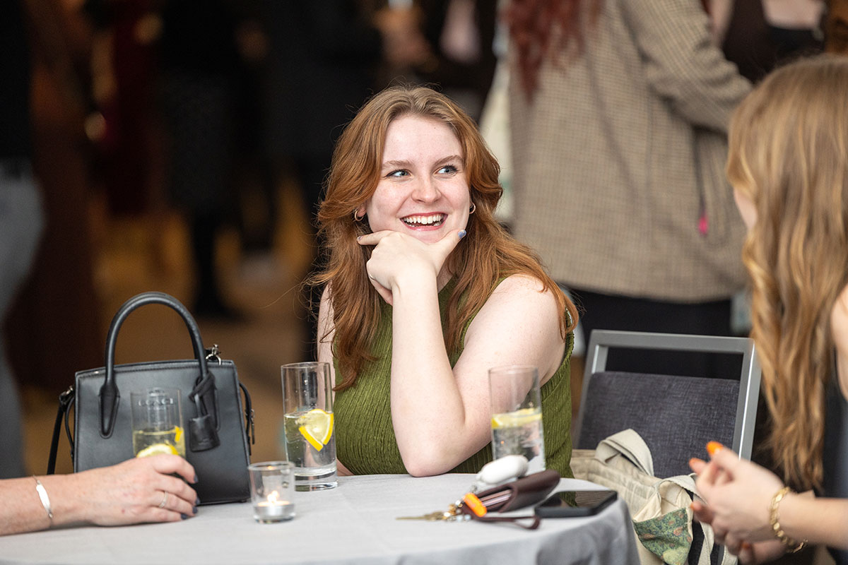 A student at a table laughs.