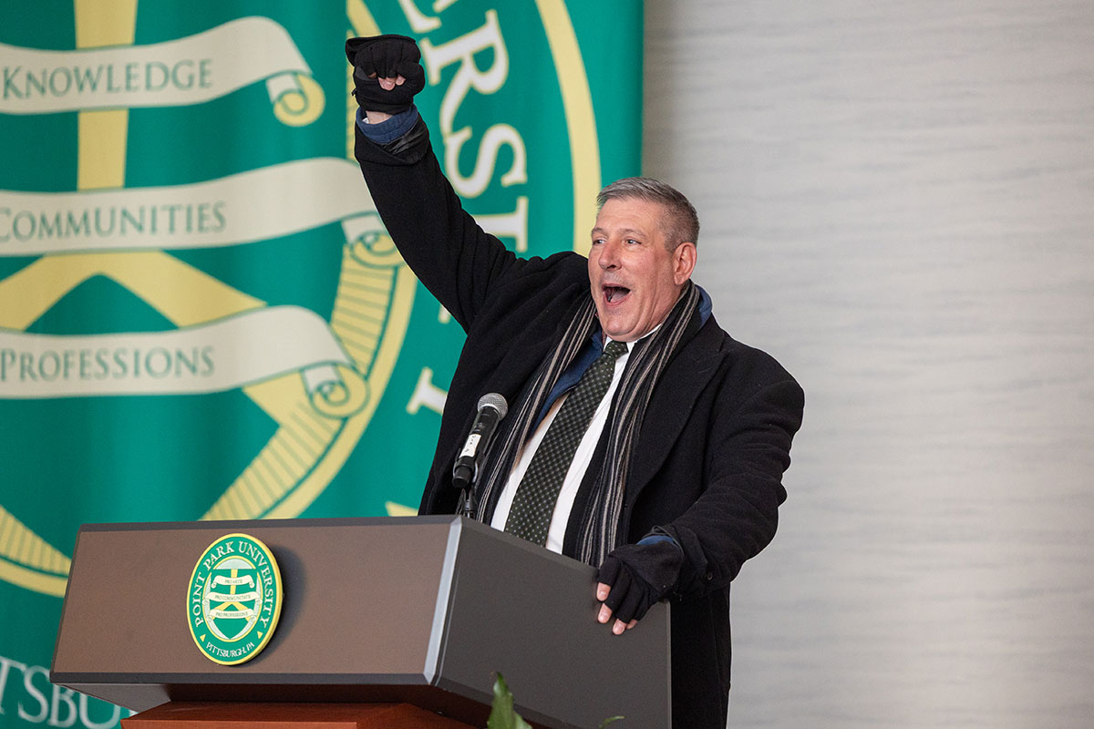 President Brussalis raises his fist in the air.