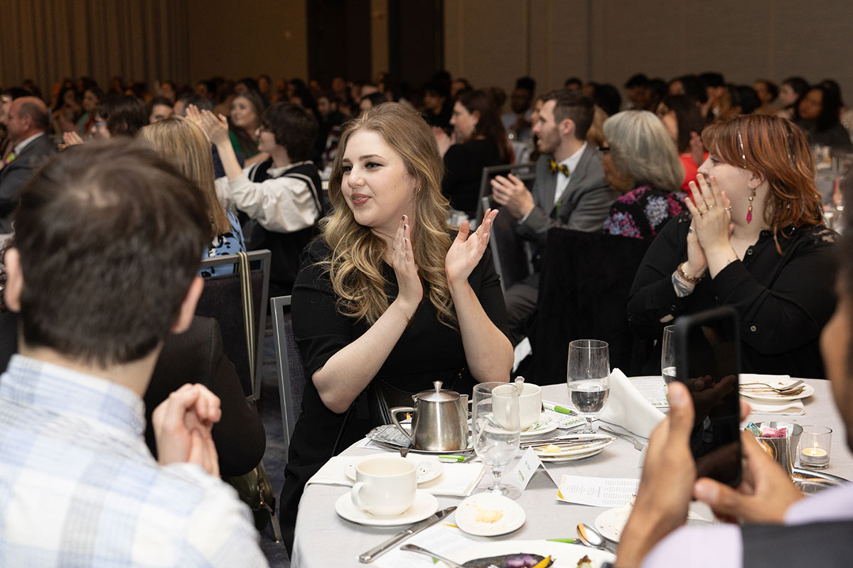 A student sitting at a table claps.