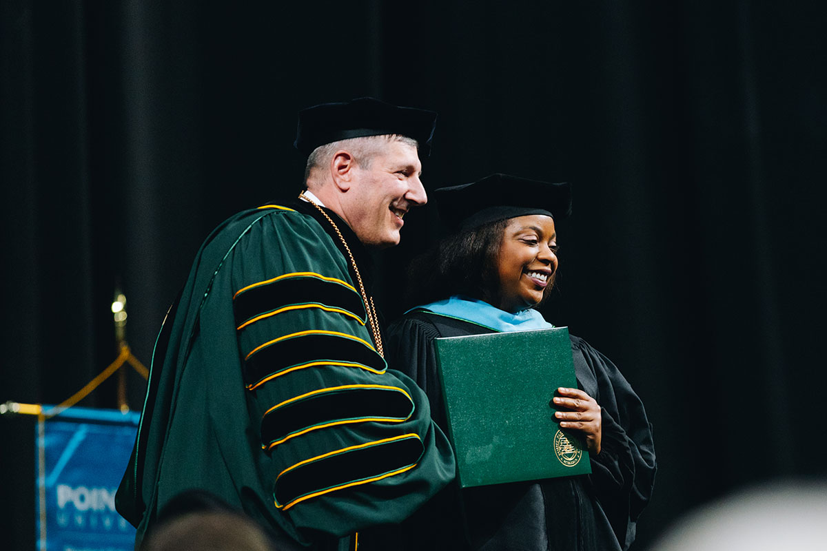 A woman shakes the University president's hand