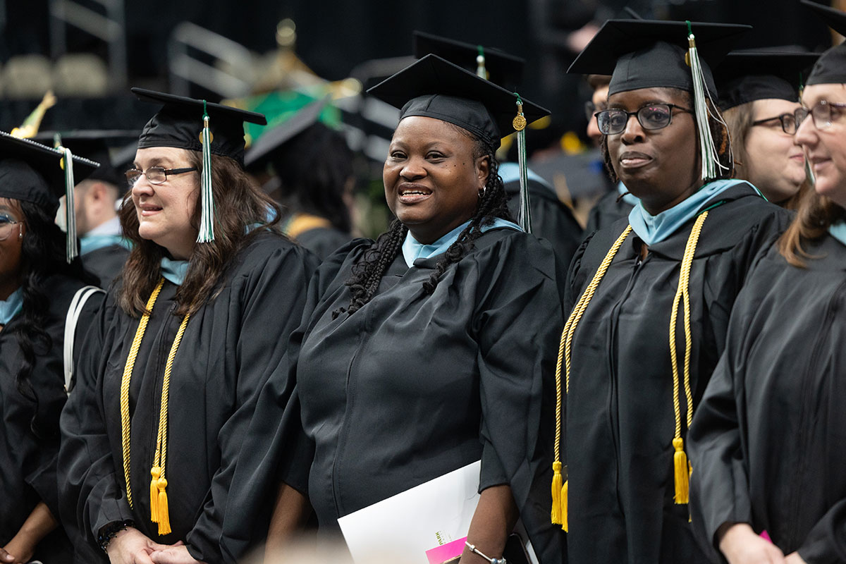 Graduates stand in a line smiling