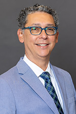 Portrait of Dr. Michael Soto with a gray background.