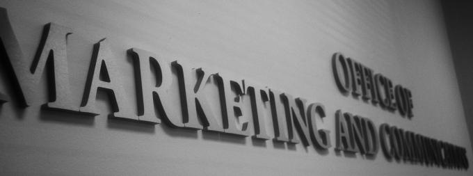 Office of Marketing and Communications signage at Point Park University in the Patterson Building lobby.