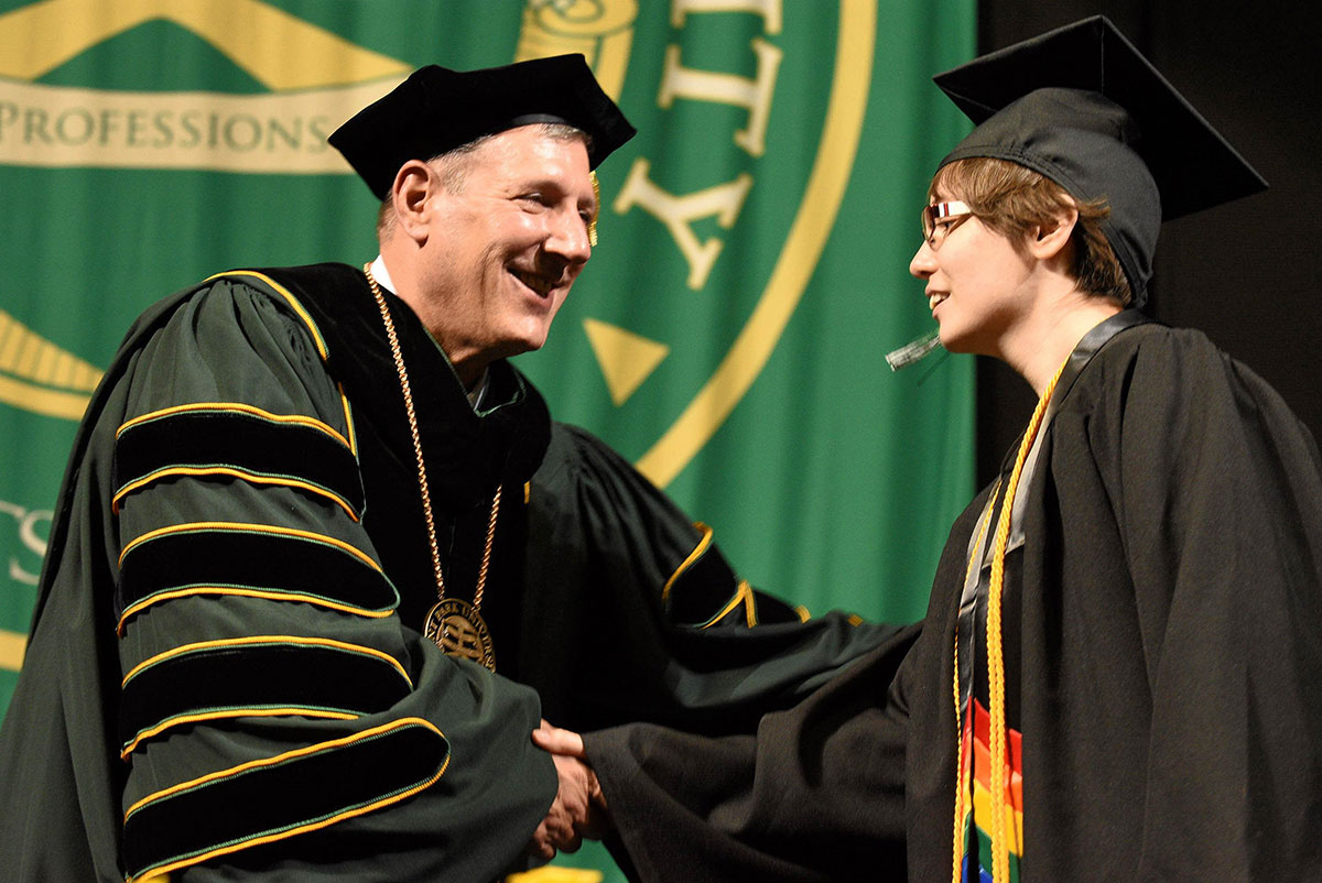 University president shakes graduate's hand
