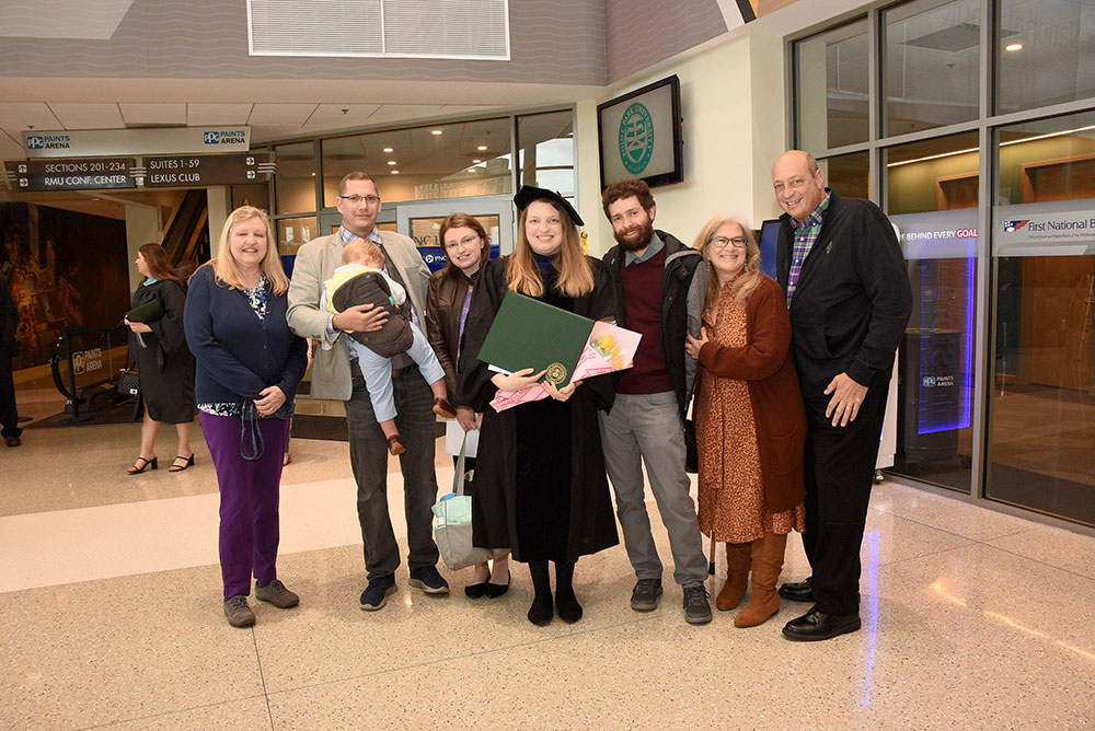 A family stands with the graduate