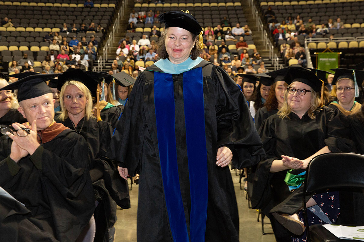 A graduate walks down the aisle