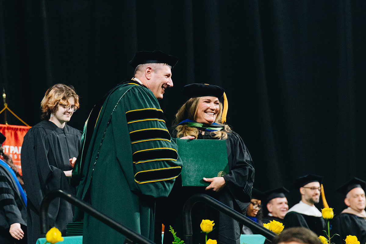 A graduate shakes the president's hand.