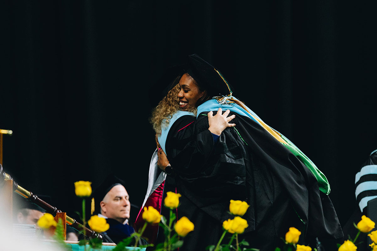 A graduate hugs their dissertation chair.
