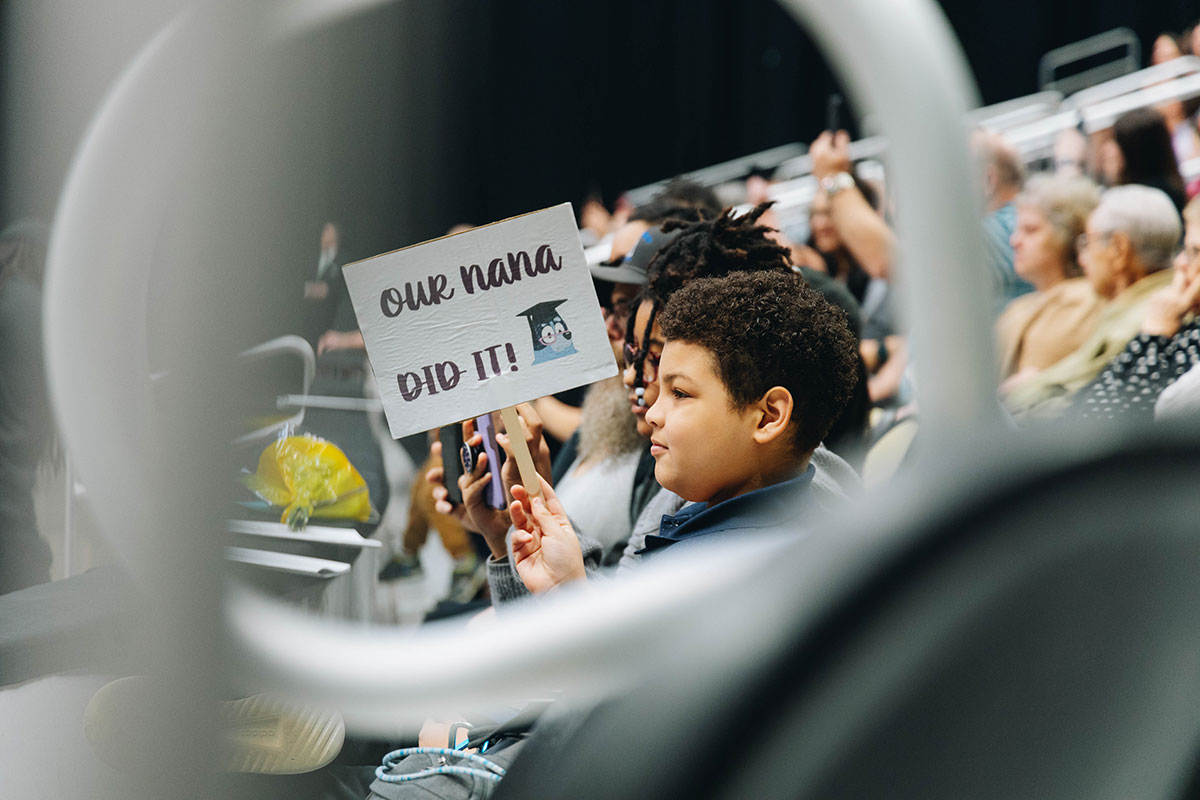 A child holds up a sign that read "My nana did it."