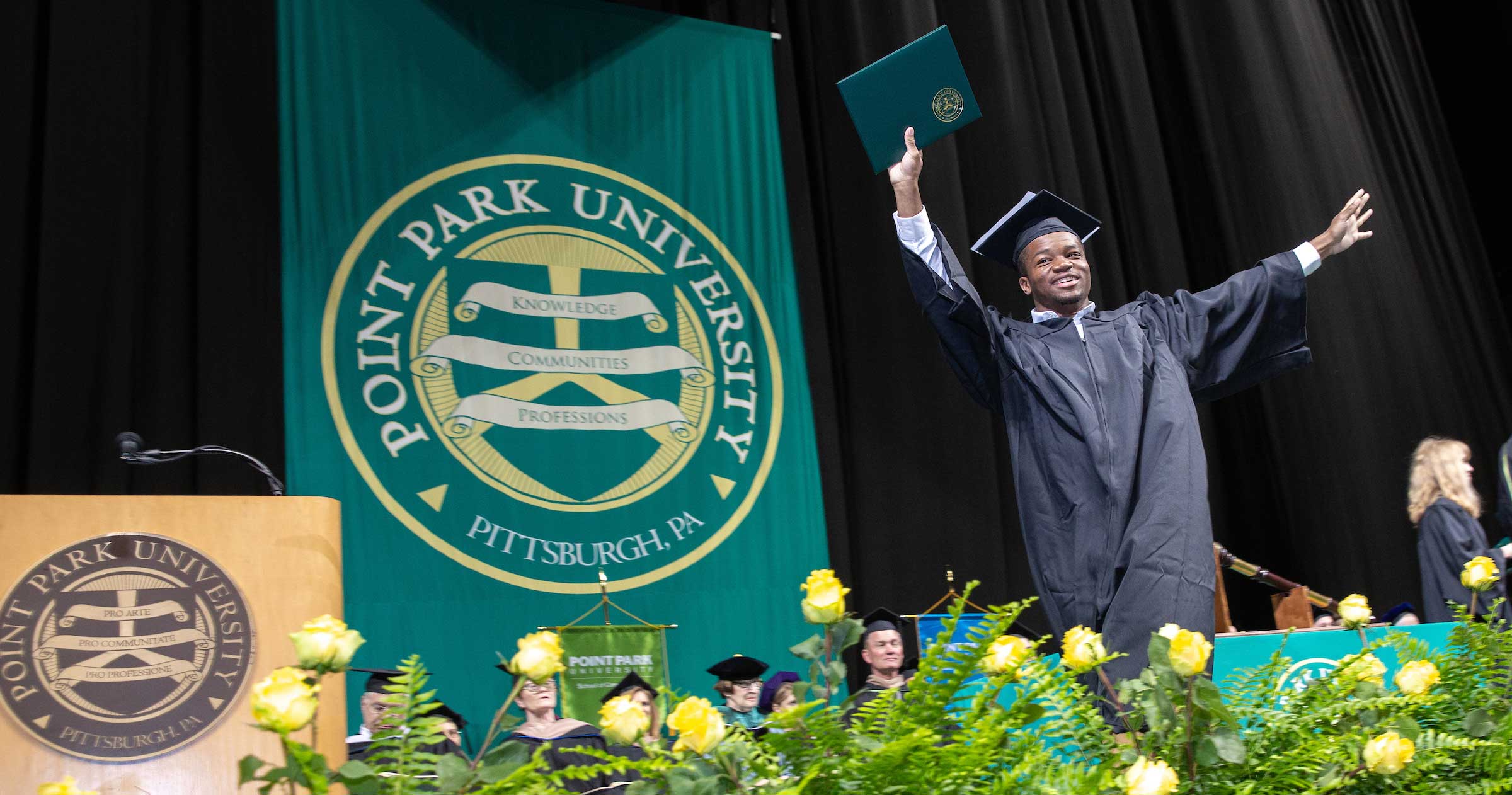 A student walking across stage after receiving his degree at commencement