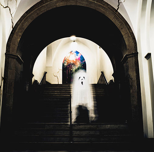 A modified image of a ghost coming down the stairs of Lawrence Hall.