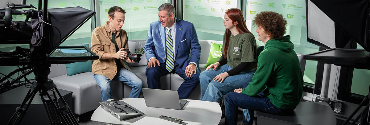President Brusallis sitting with students in the Center for Media Innovation