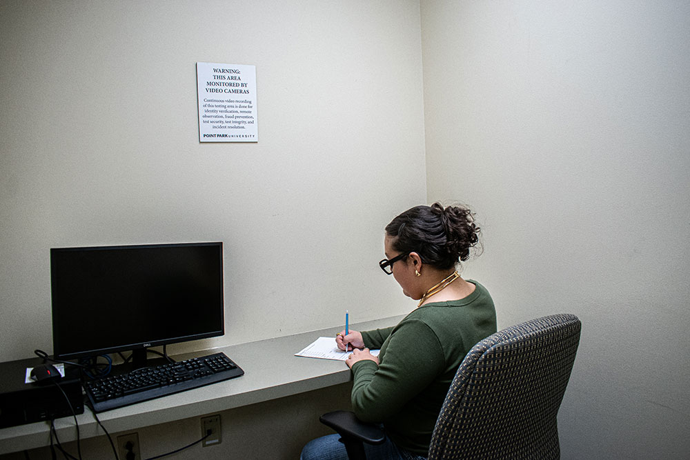 A student takes a test in a small private room.