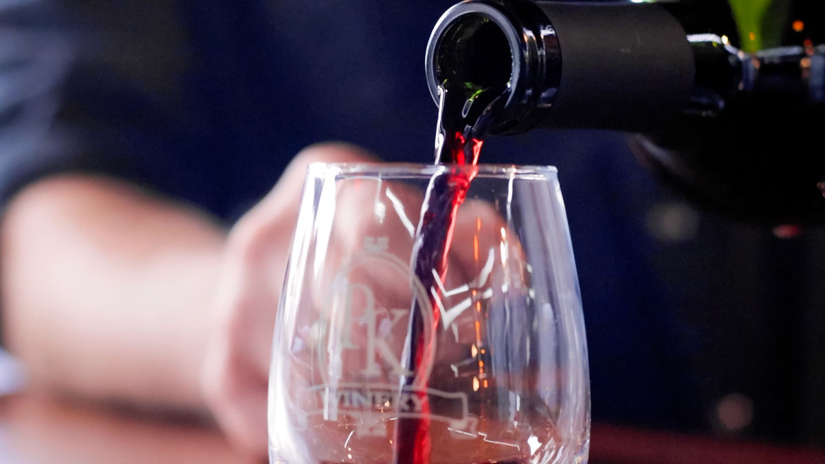 A glass of wine being poured. 