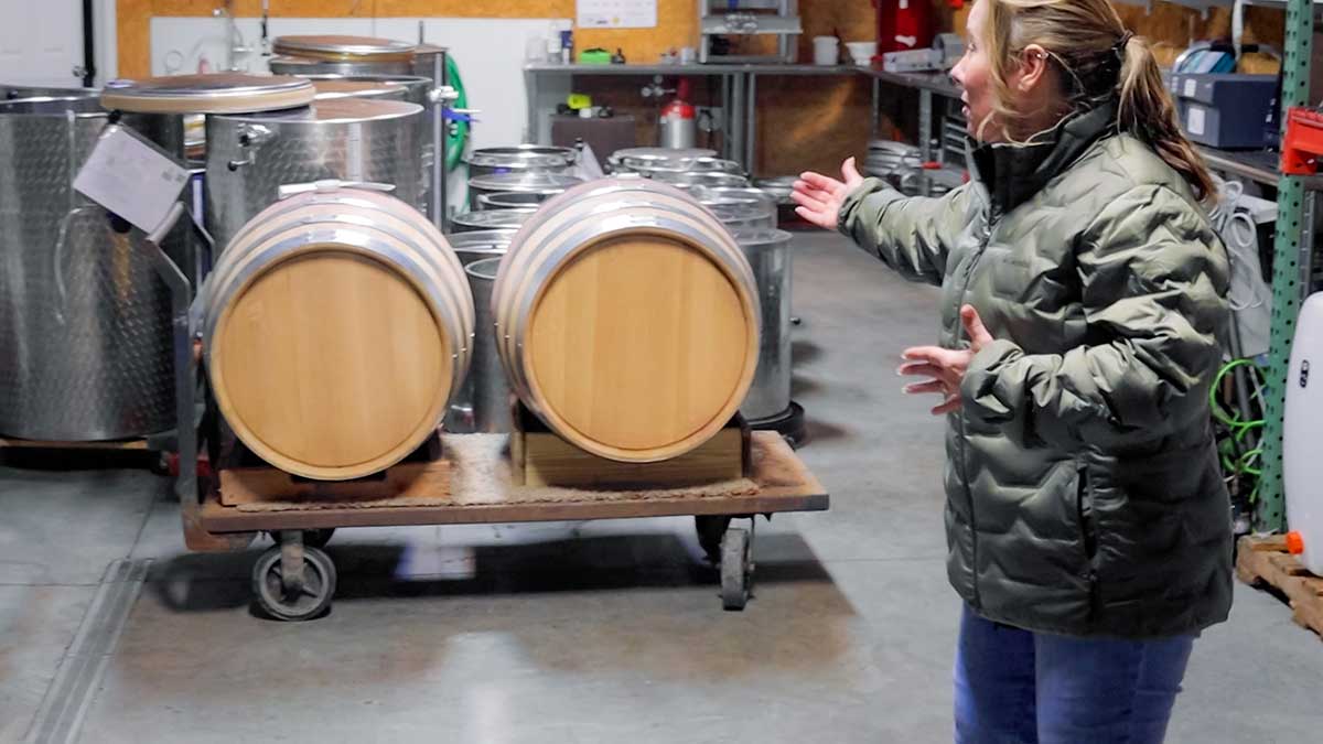 Pictured is a woman pointing to barrels.