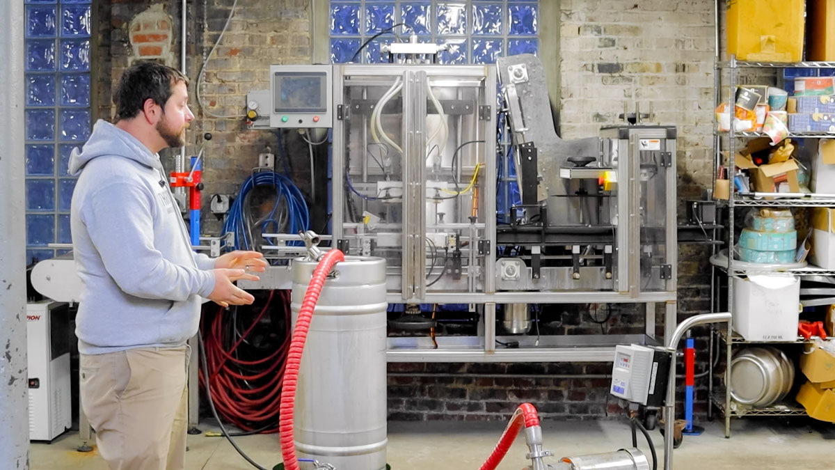 Pictured is a man in a cider-making setting.