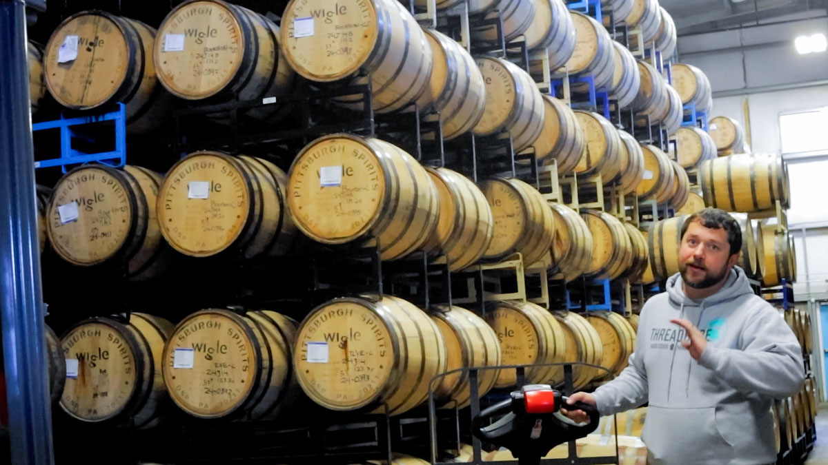 Pictured is a man by many barrels.