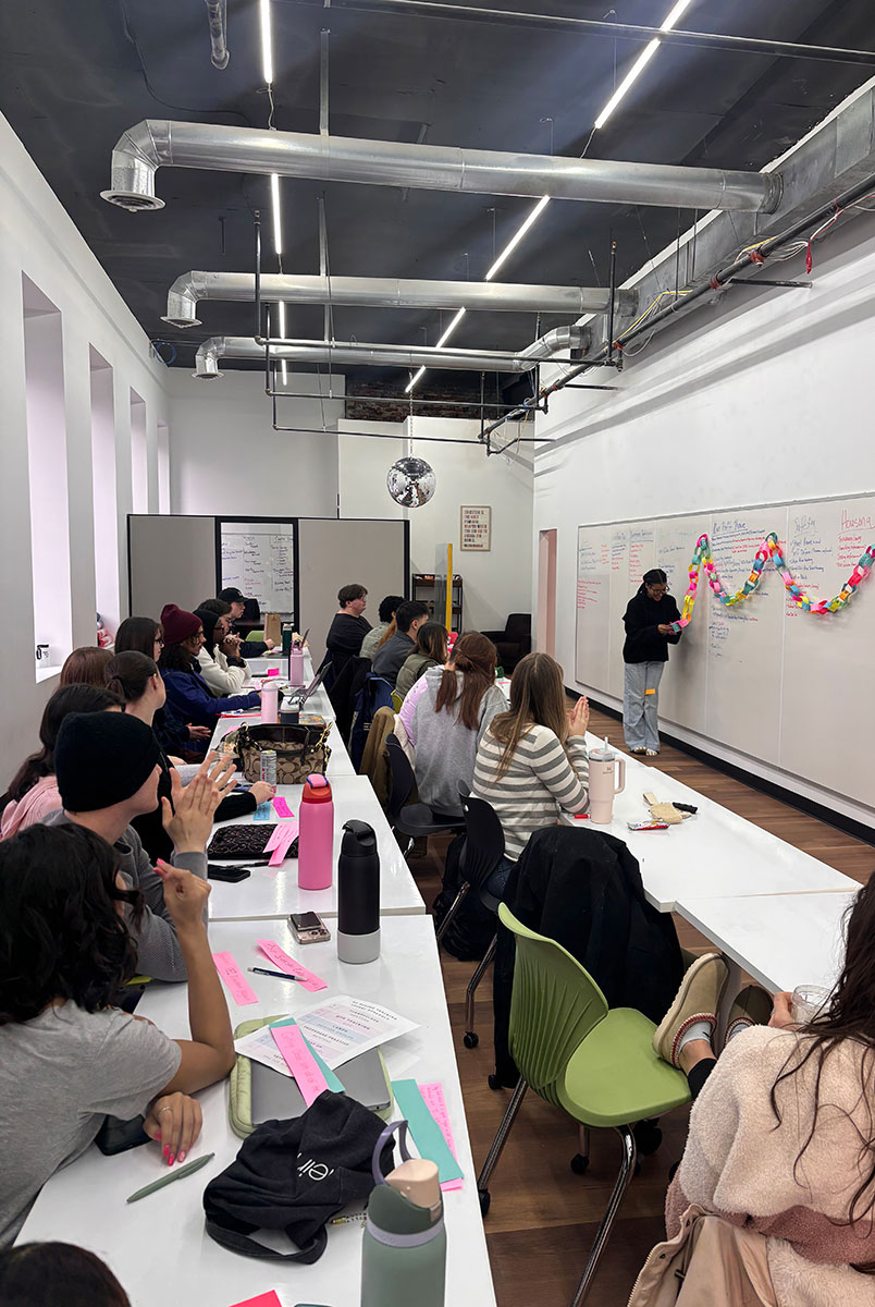 Students sit at rows of tables in the Center for Civic and Community Engagement.