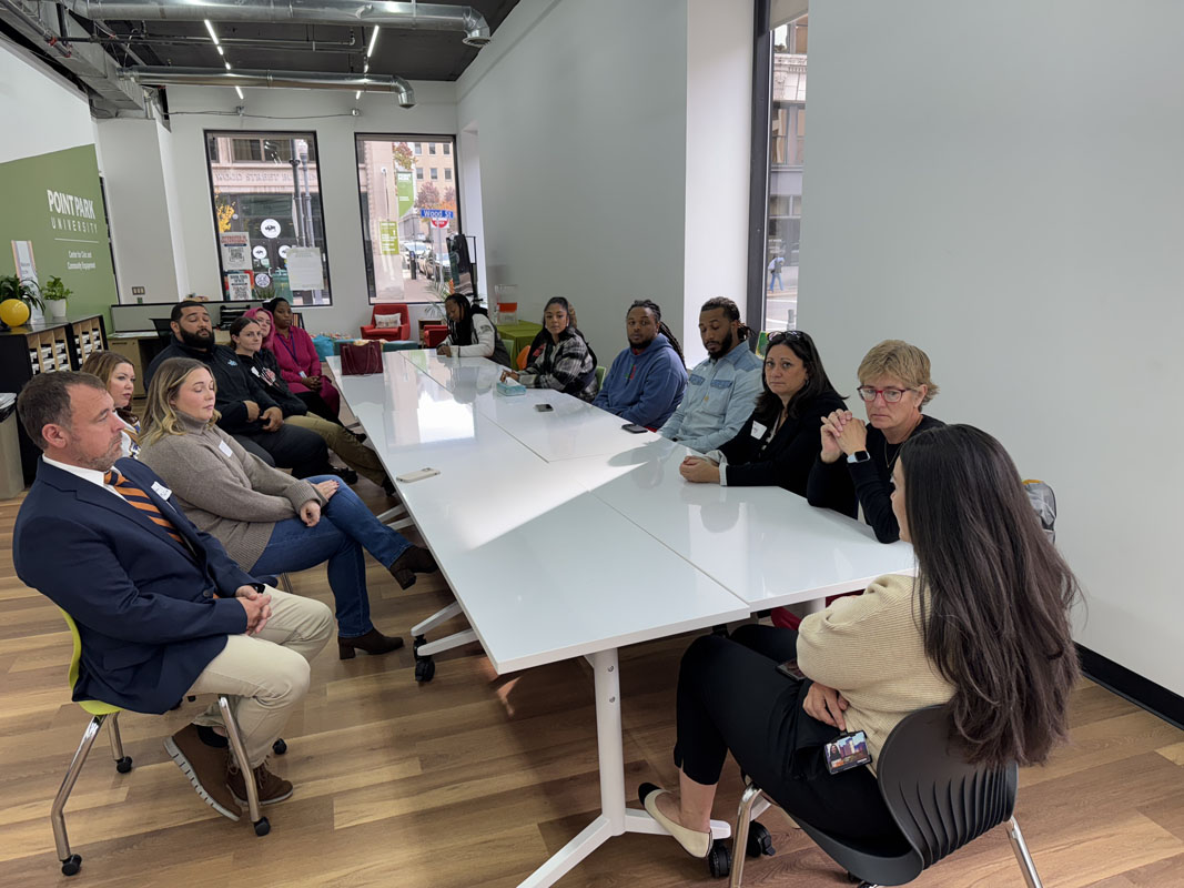 People sit around a long white table in the Center for Civic and Community Engagement.
