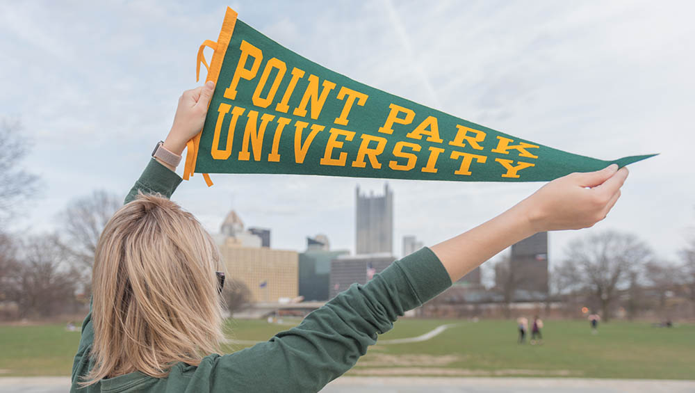 A Point Park student holds a banner in Point State Park. Photo | Nick Koehler