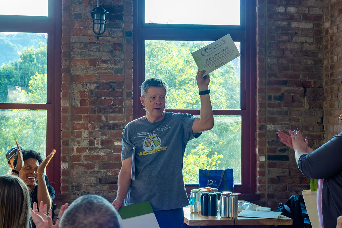 Gregg Johnson holds a certificate in the air.