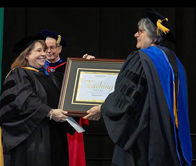 Pictured is Vincenne Revilla Beltrán, professor and Ccordinator of the M.A. in adult learning and training program, receiving the 2019 Distinguished Teaching Award.