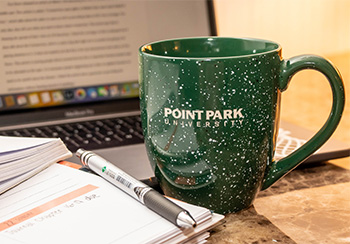 Pictured is a Point Park mug and laptop. Photo by Mallory Neil.