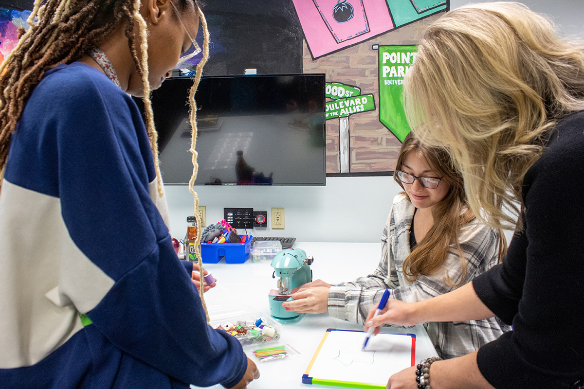 Pictured students and Professor Virginia Chambers working together in the Matt's Maker Space Lab. Photo by Madi Fisher.