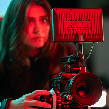 A student experiments with a camera as red light colors the photo.
