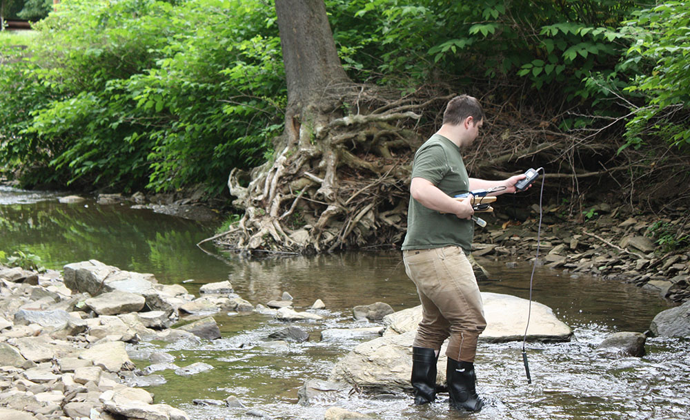 Pictured is a student Matthew Love conducting a stream survey at Lowries Run. Photo by Matthew Opdyke, Ph.D.
