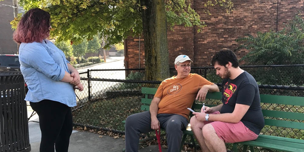 A man interviews a resident as part of the citizen reporting academy. 