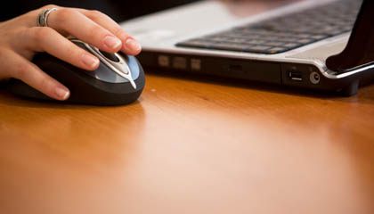 Stock image of a computer mouse and a laptop computer, to depict financial aid issues. 