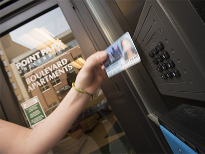 Pictured is a Point Park student swiping their ID to get into the Boulevard Apartments.