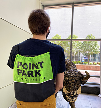 Pictured is a Point Park Admissions staff member wearing a Point Park green totebag.