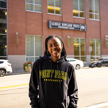 A student stands in front of the George Rowland White Performance Center. 